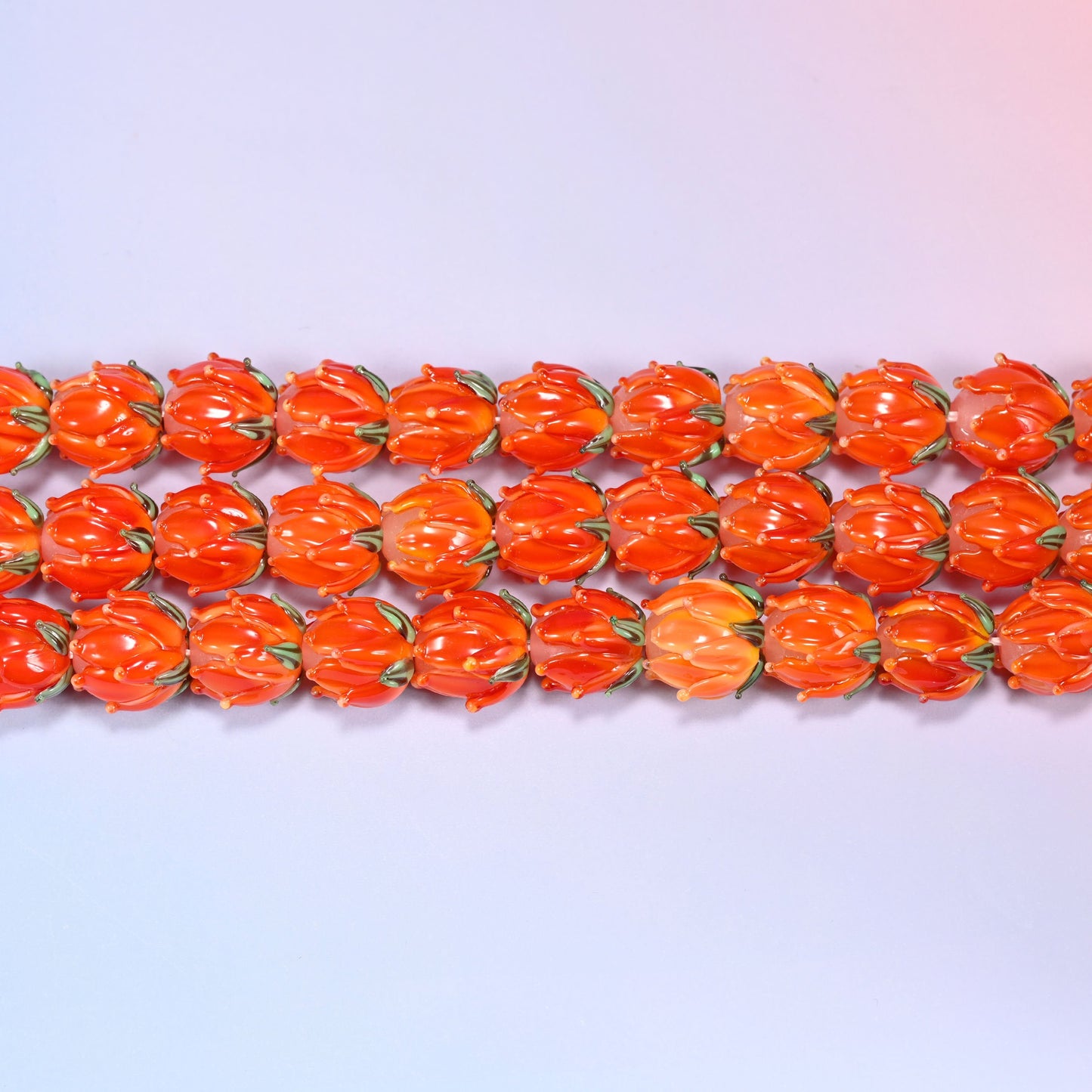 Tulip flower bud lampwork glass beads in orange with green leaf detail