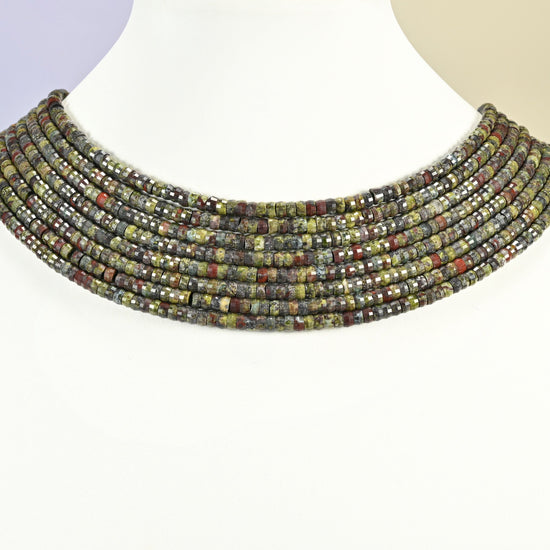 Dragon blood stone faceted heishi disc strands arranged as a layered collar on a white display bust, green and red beads across the neck