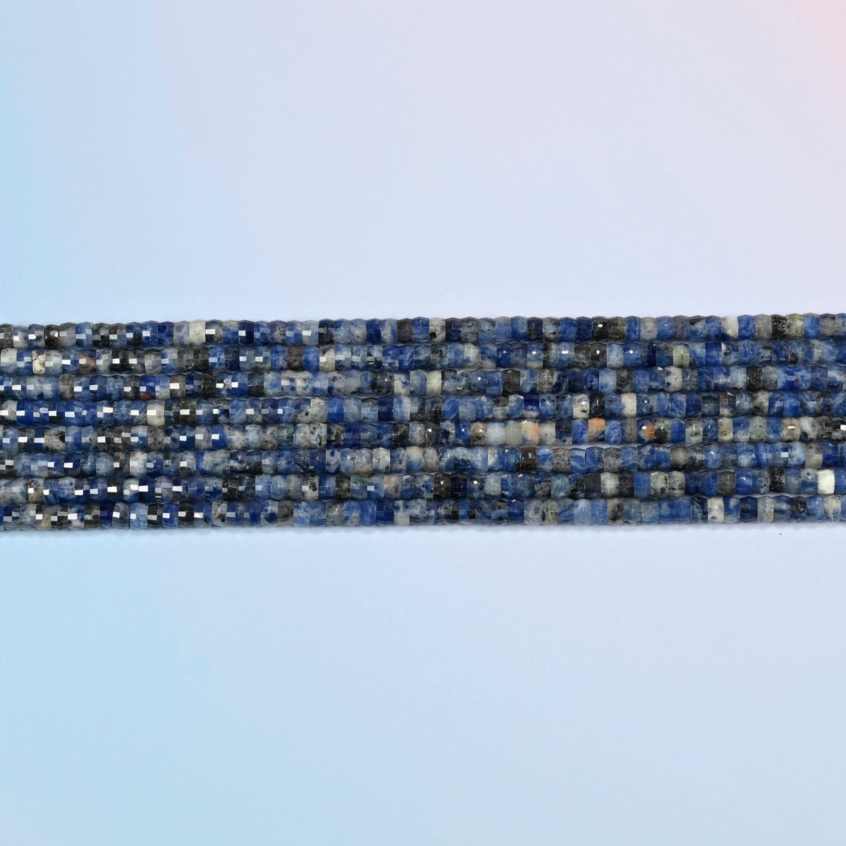 Several strands of sodalite faceted heishi disc beads laid in straight rows