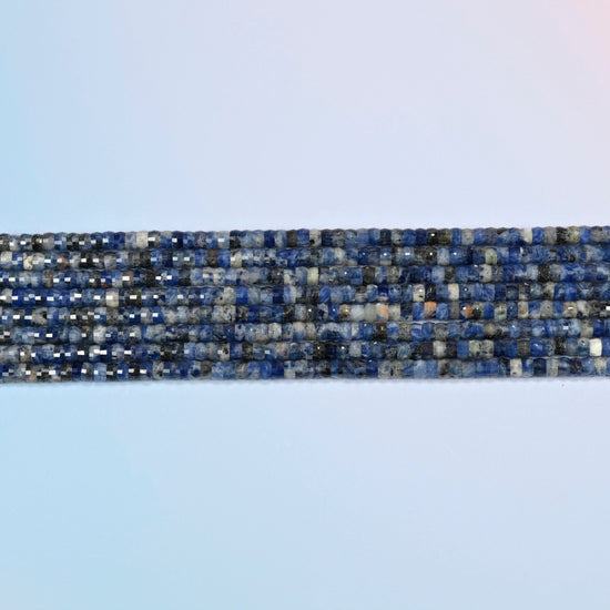 Several strands of sodalite faceted heishi disc beads laid in straight rows