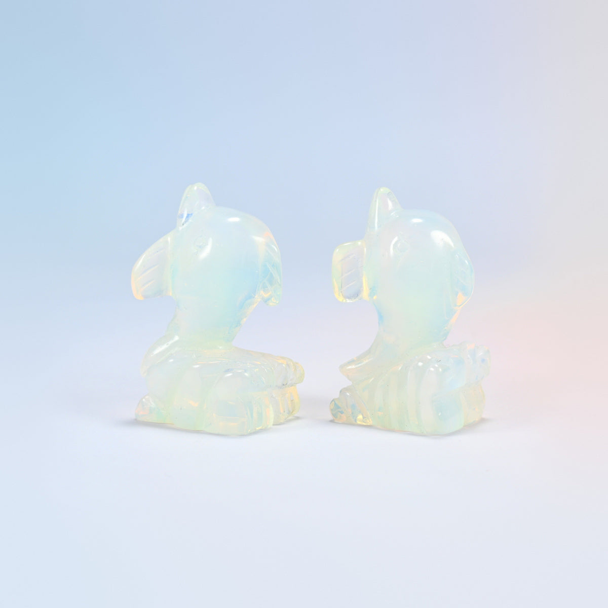 Close view of two opalite dolphin carvings showing the curled tail