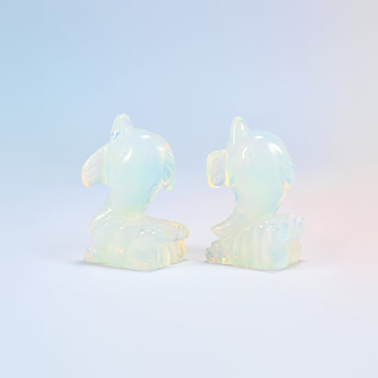 Close view of two opalite dolphin carvings showing the curled tail