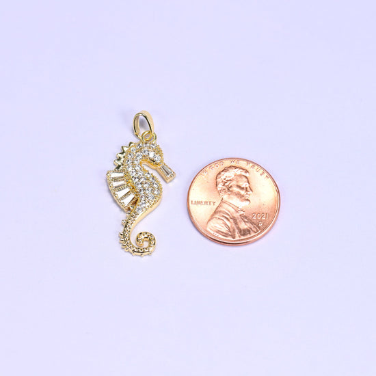 Sea horse zirconia charm scale shot, the gold seahorse pendant photographed beside a US penny.
