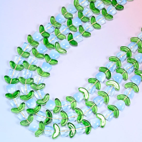 Close-up of a circular coil of light blue tulip and green leaf glass beads on a lavender background.