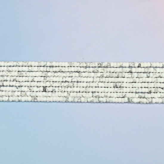 Several strands of white howlite faceted heishi disc beads laid in straight rows