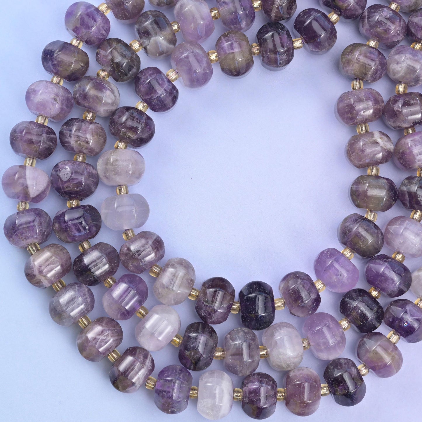 Open ring of strands laid flat on lilac, the ribbed rondelle profile repeating all the way round