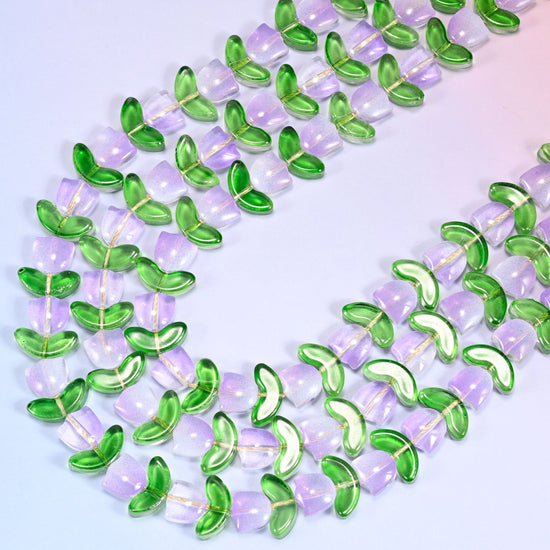 Close-up of tulip and leaf glass bead strands coiled in a tight spiral pattern on a lavender background.