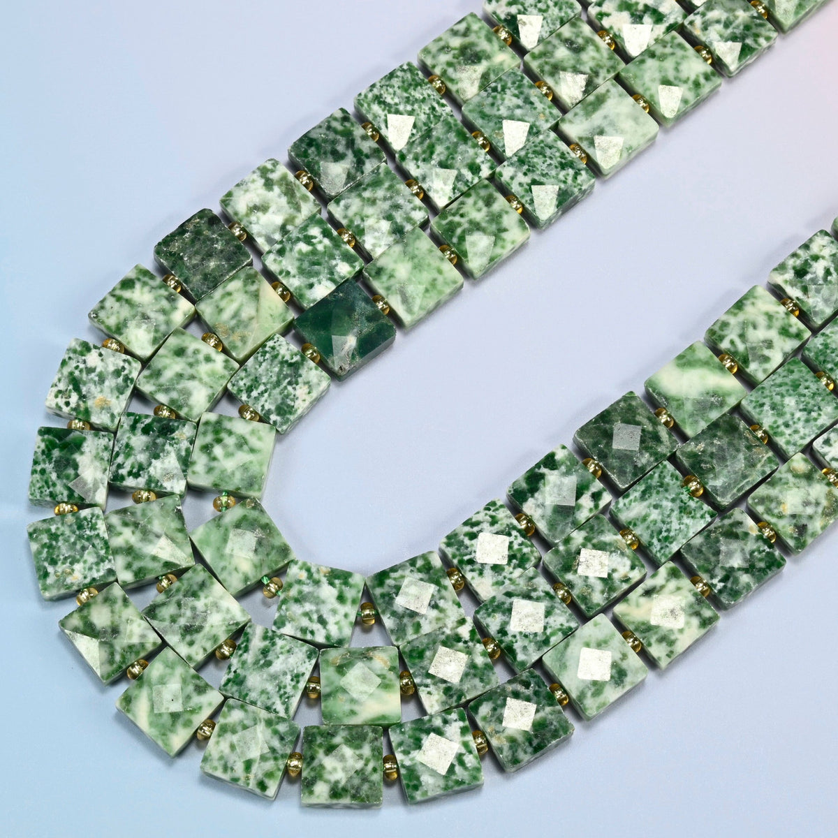 Tree agate faceted flat square beads in several strands curved into a wide U, white stone with green dendrite spots