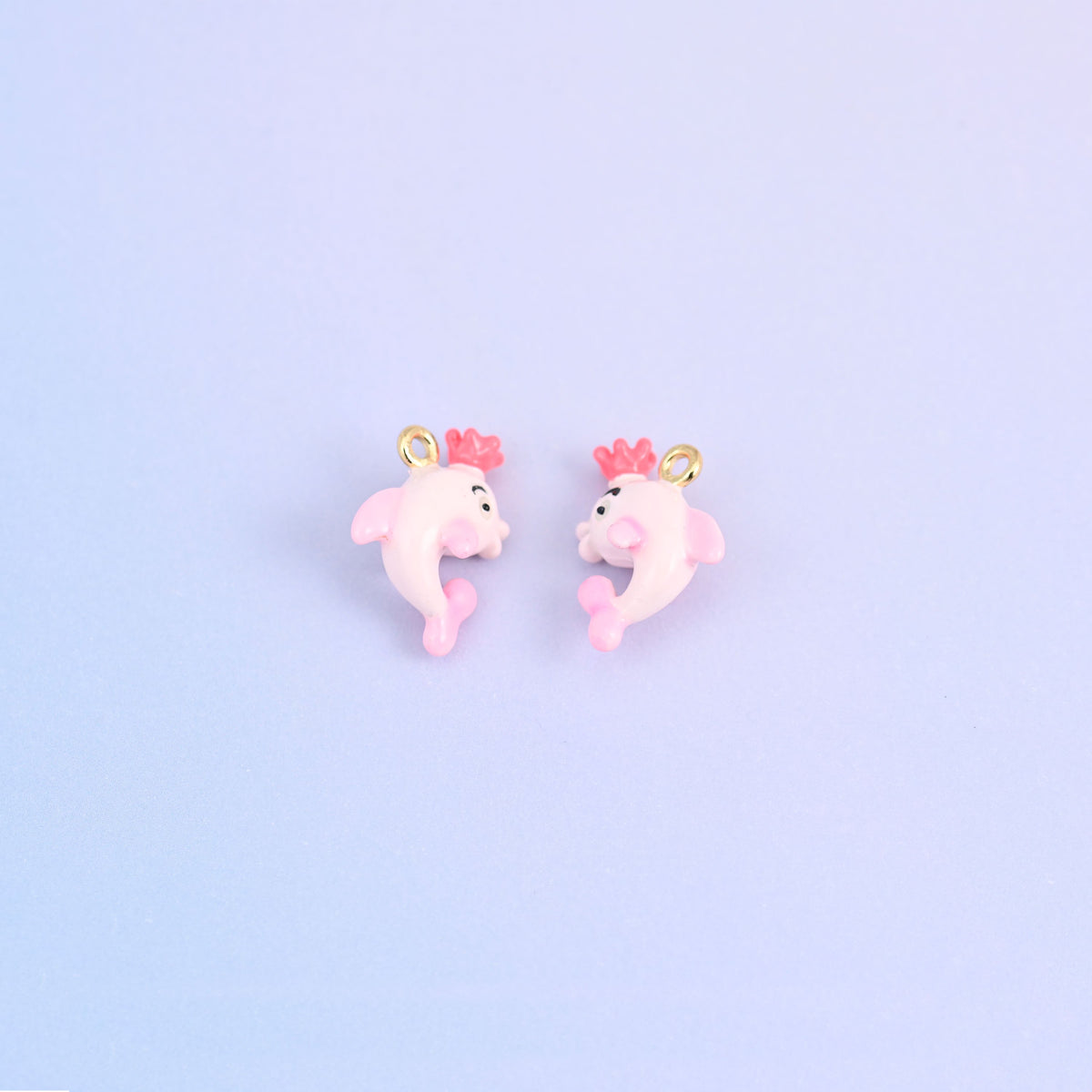 Two pink dolphin charms with crowns, front and back, 17.30 x 13.10mm with a small ring.