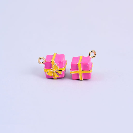 Two pink gift box charms with yellow enamel ribbon and bow.