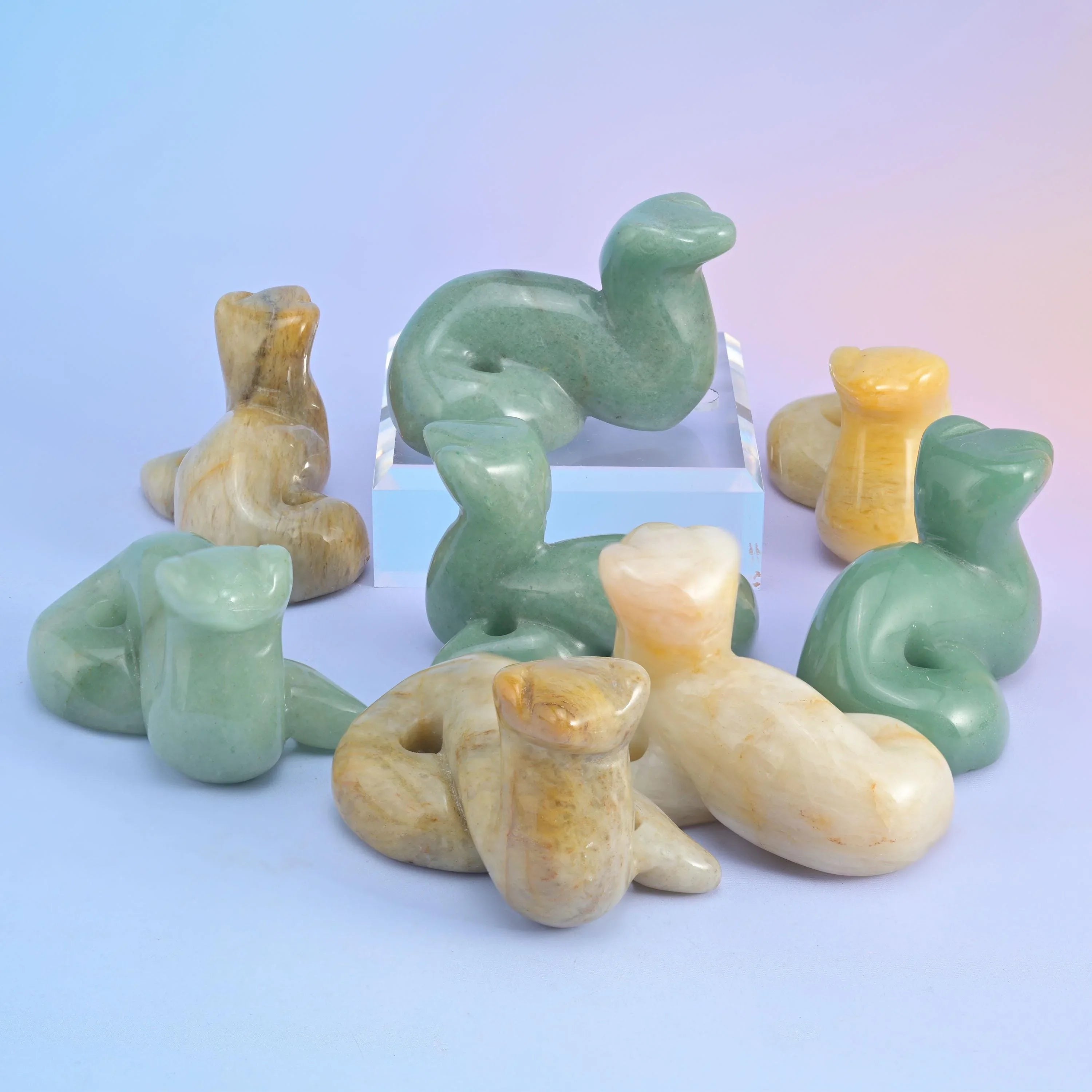 Glossy black obsidian snake figurines massed on a pale blue background