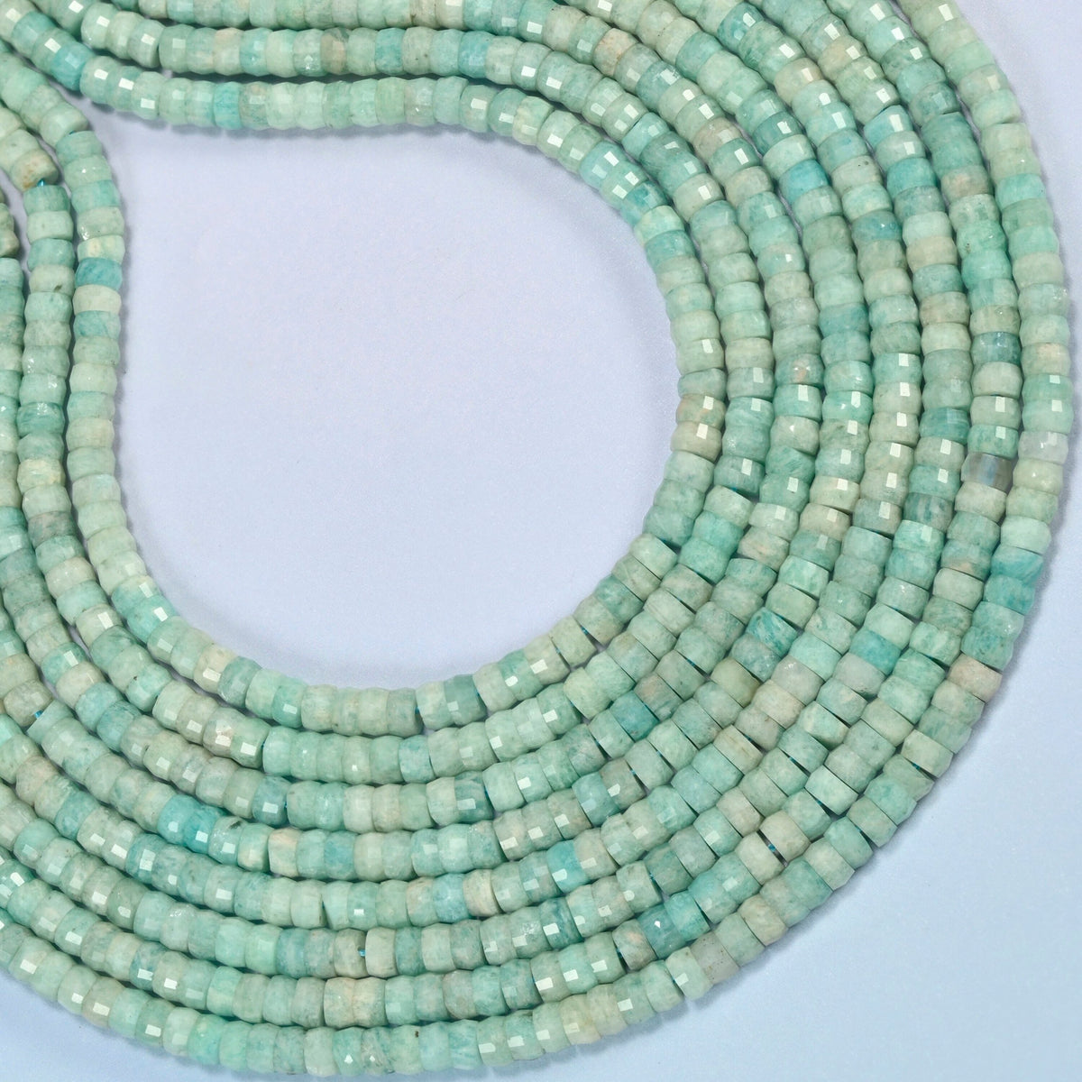 Green amazonite faceted heishi disc beads curved into an open loop, light green and light beige beads