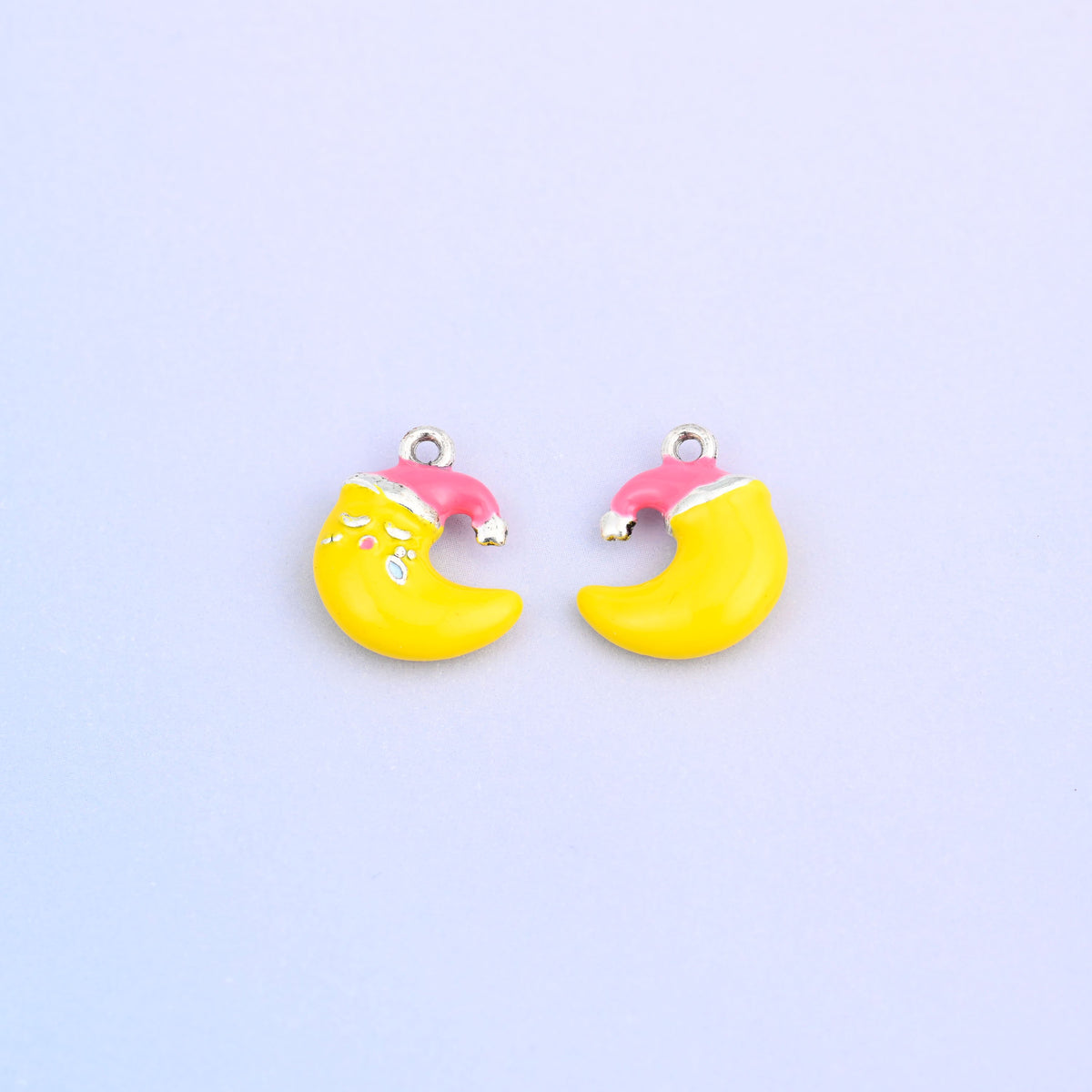 Yellow crescent moon charm in a pink Santa hat, front and back.