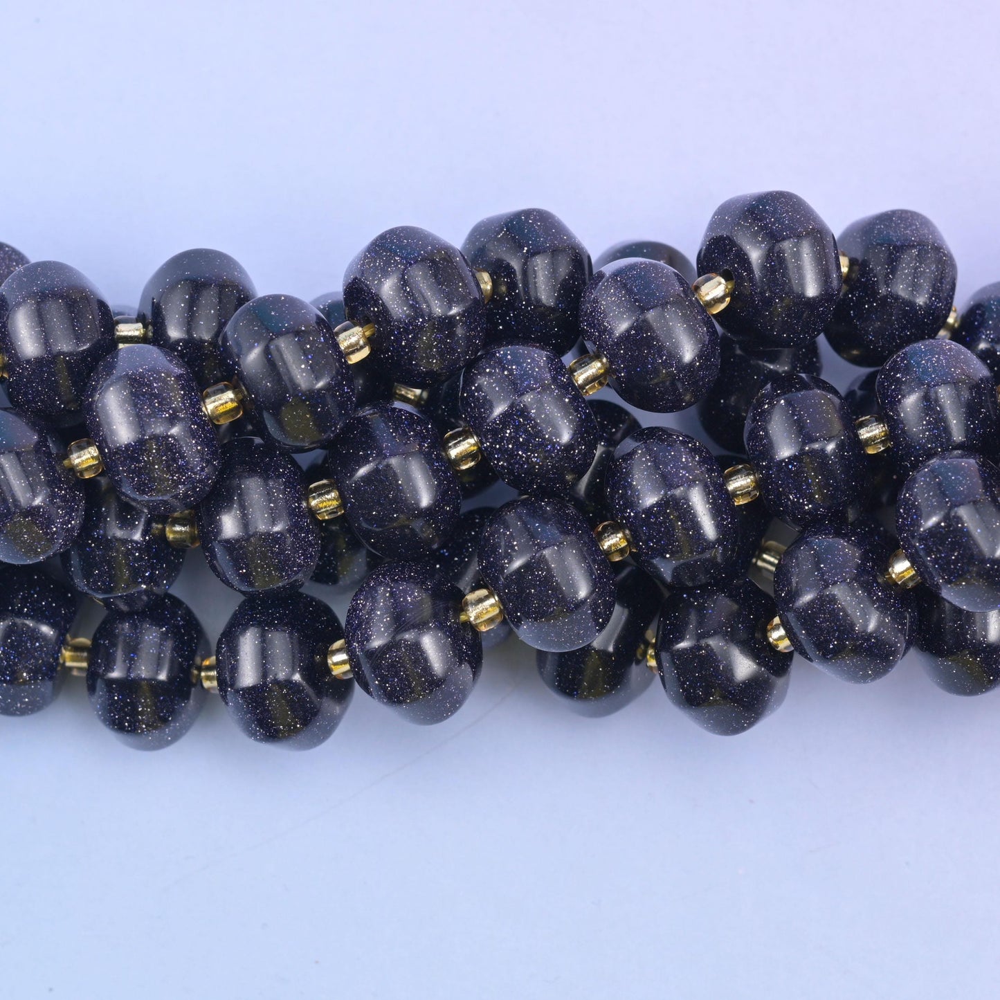 Close view of grooved Blue Sandstone pumpkin beads showing copper glitter flecks