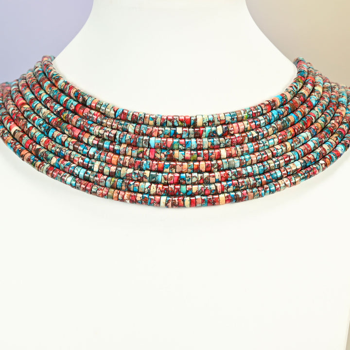 Dyed red blue sea sediment jasper heishi disc strands arranged as a layered collar on a white display bust