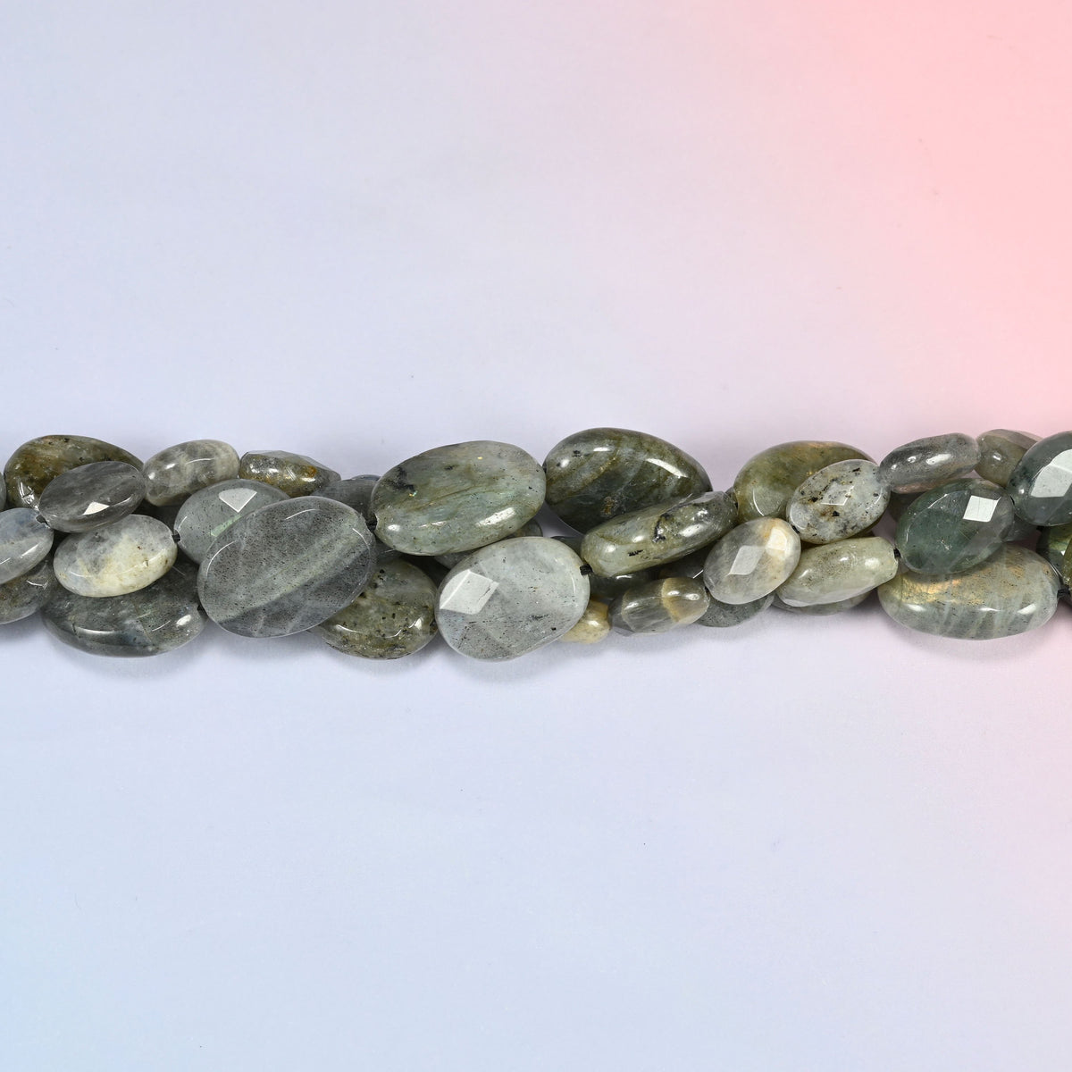 Gray Labradorite faceted oval beads in a single close run, faceting worked across the face of each oval