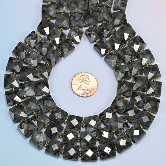 Natural black labradorite faceted flat square strands formed into a teardrop loop around a US penny for scale