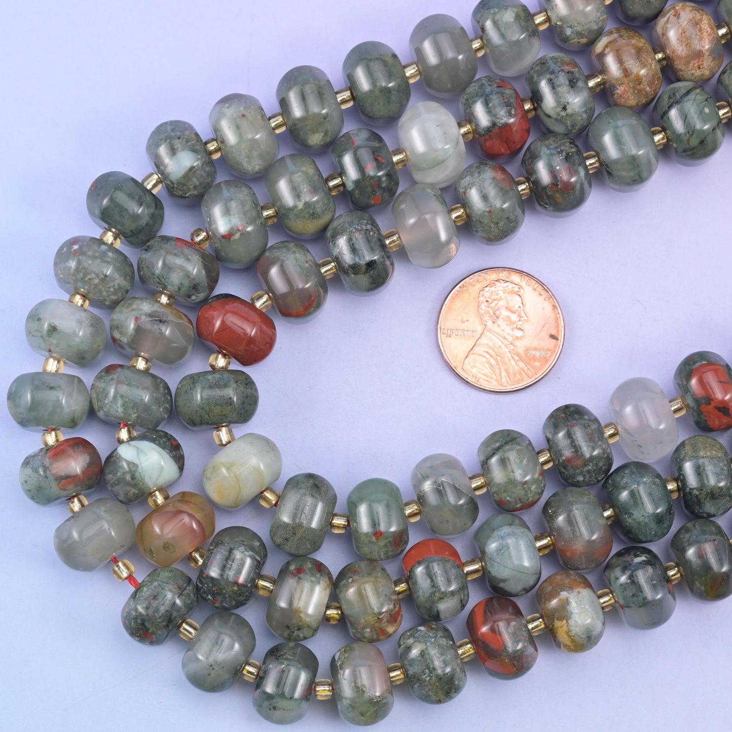 Pumpkin rondelle strands looped around a US penny to show the 12x8mm bead scale