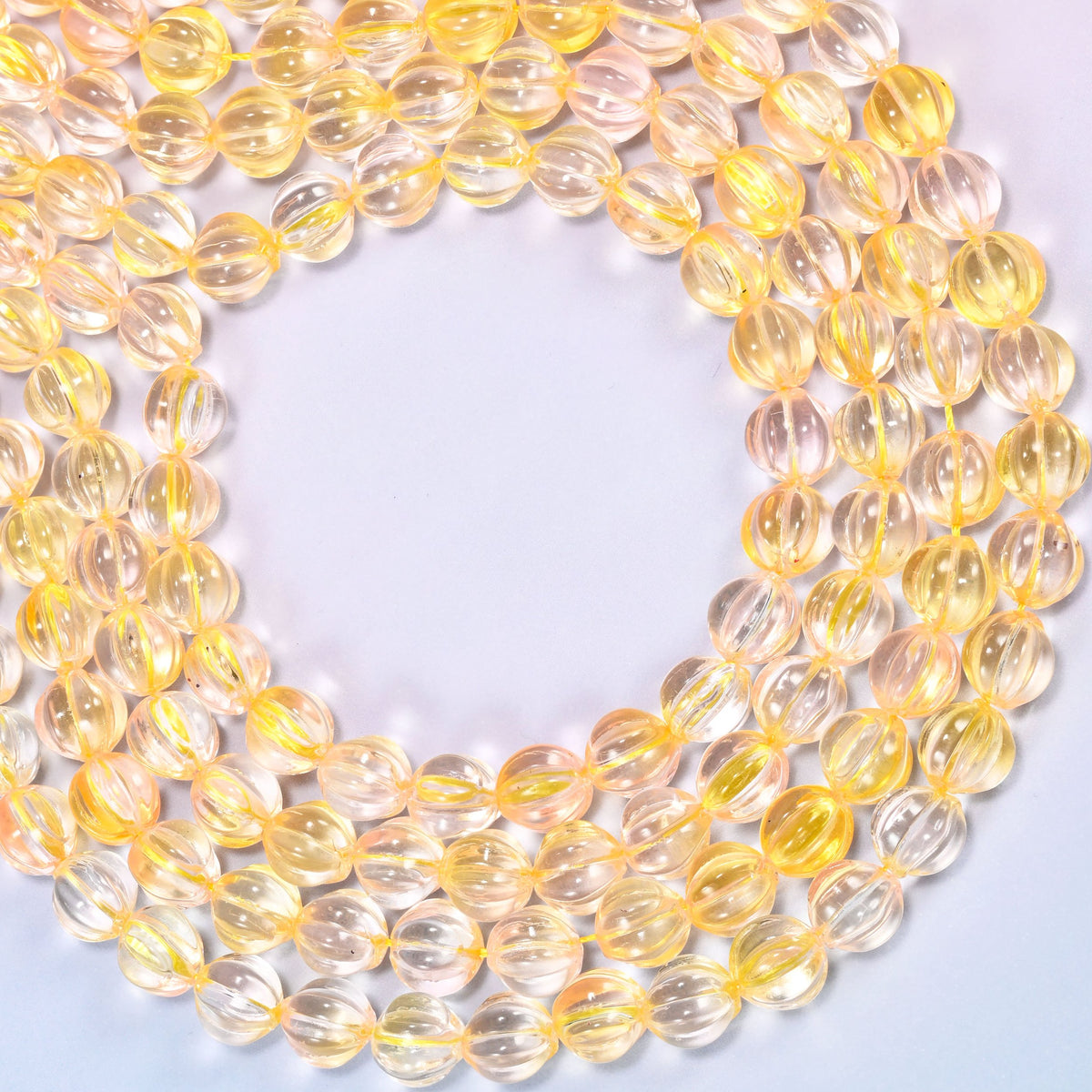 Yellow clear pumpkin glass beads coiled into a wide open ring, the fluted grooves catching the light.