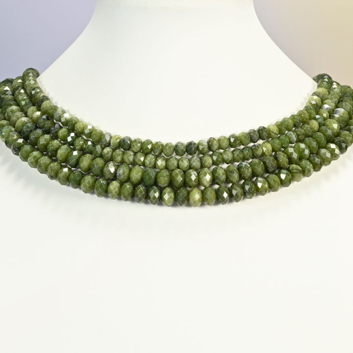 South Green Jade faceted rondelle beads shown on a white neck display, several 15 inch strands sitting together like a collar at 4x6mm and 5x8mm.