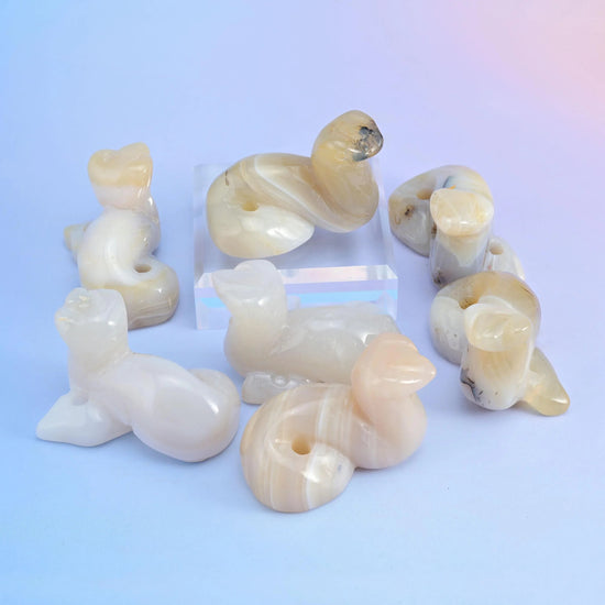 Milky opalite snake figurines with a soft translucent blue glow