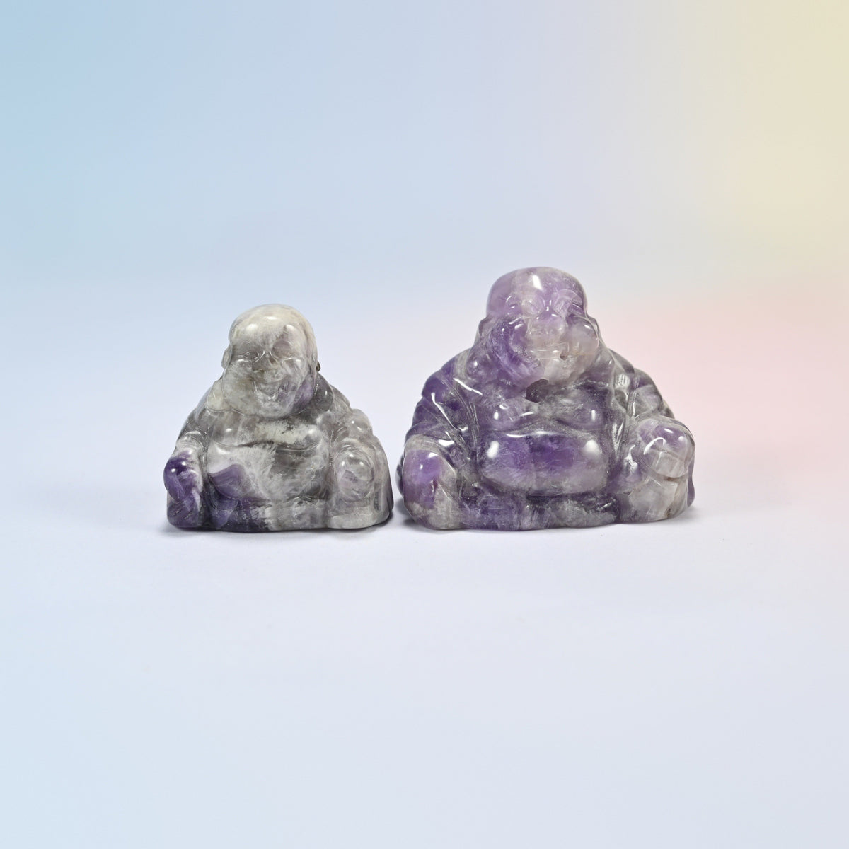 A 1.5 inch and a 2 inch amethyst laughing Buddha crystal carving, purple and white banded natural stone