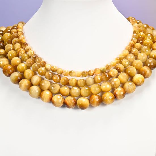 Close-up of golden brown gold tiger eye round beads, showing the faceted finish and natural brown tone.
