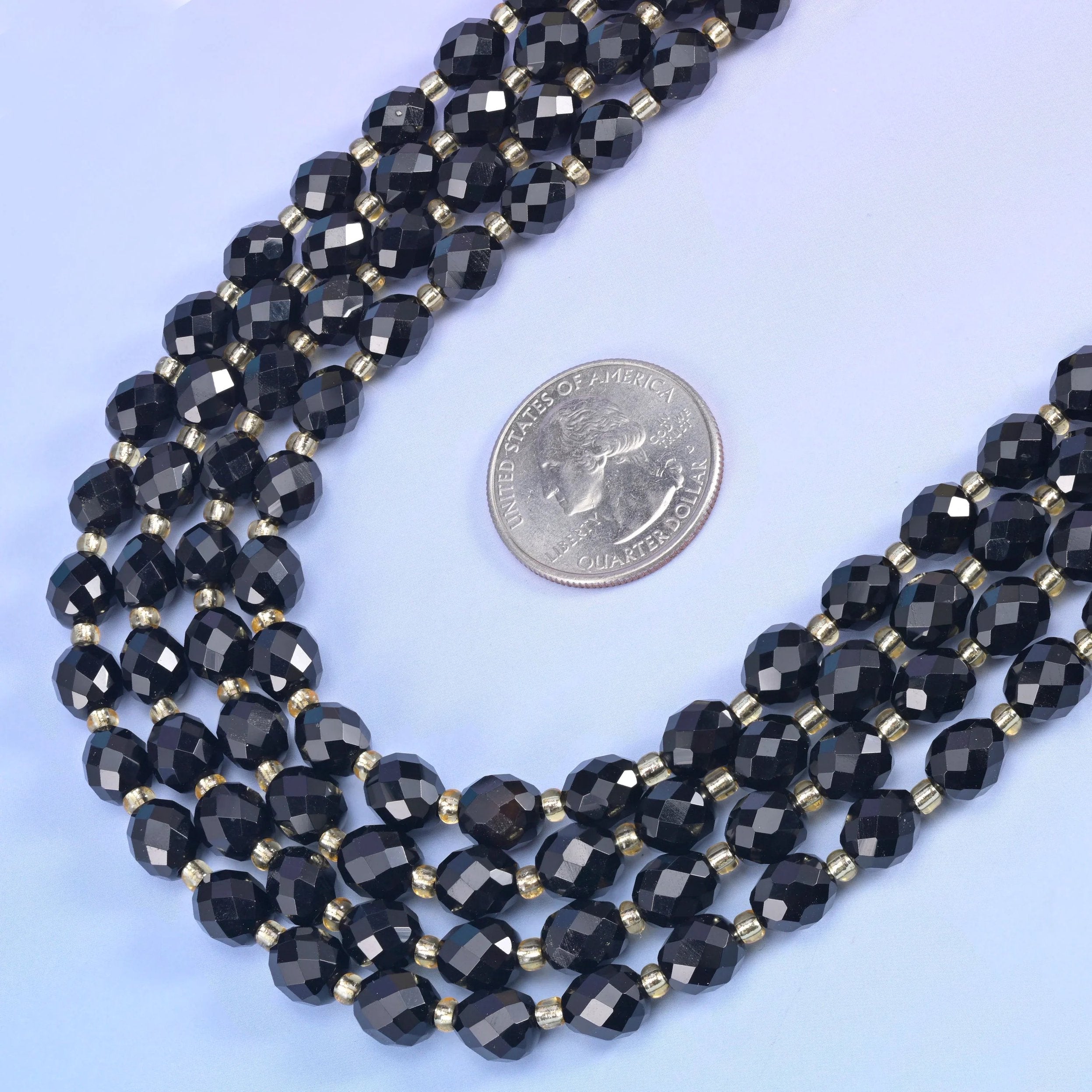 Black Onyx faceted barrels polished until each plane returns a small hard highlight.