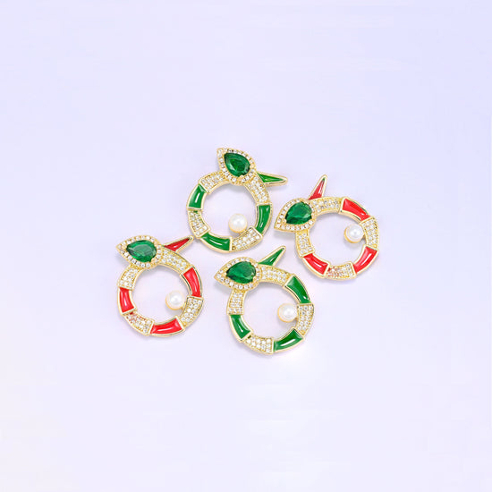 Four round snake charms grouped at an angle, two green and two red enamel pieces with pave zircon, pear cut green stones and pearl centres.