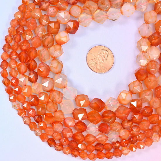 Orange Agate diamond star cut beads coiled around a US penny for size reference, centre drilled