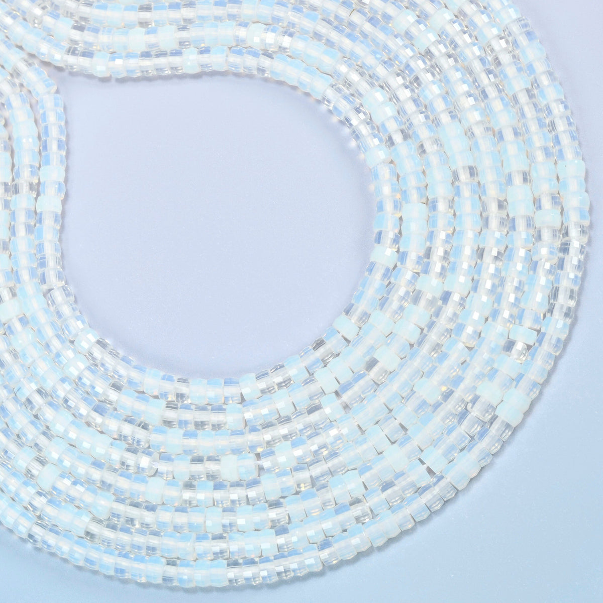 Opalite faceted heishi disc beads curved into an open loop, milky white beads with a soft blue glow