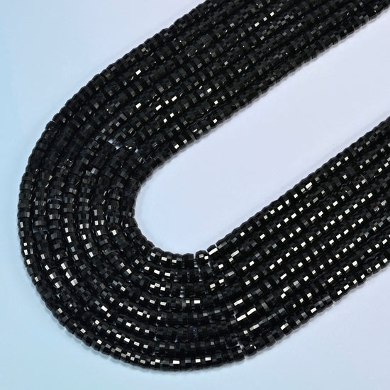 Black onyx faceted heishi disc beads in several strands curved into a wide U, solid glossy black stone
