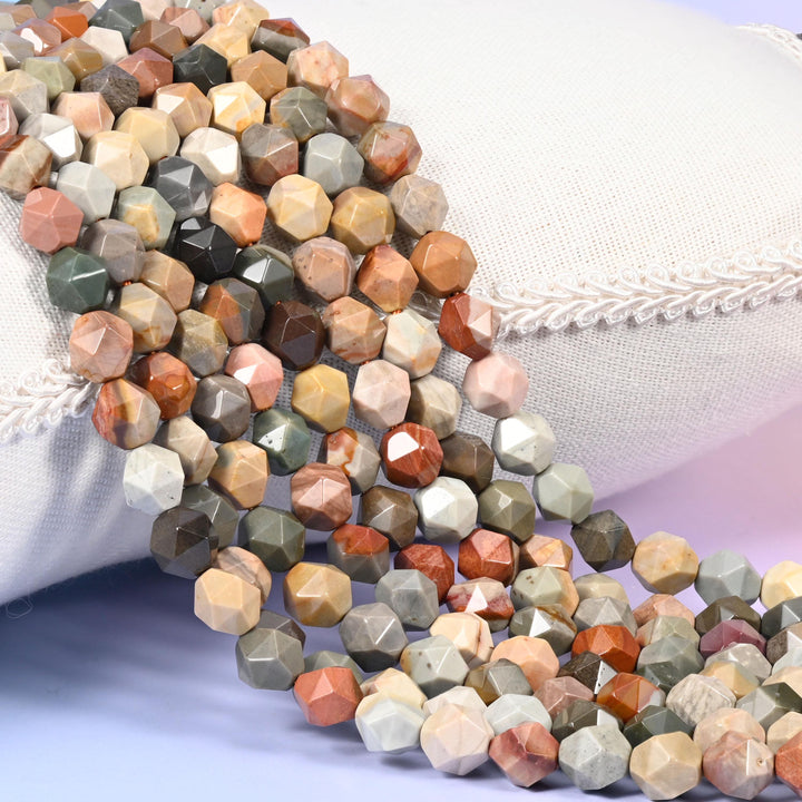 American Picture Jasper diamond star cut beads, strands laid over white fabric, mixing tan, rust, grey-green and cream beads