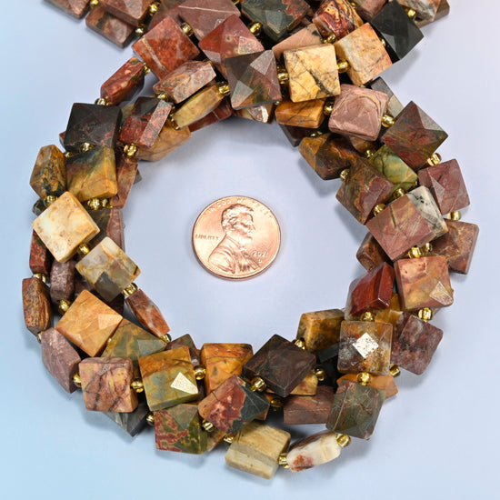 Natural red howlite faceted flat square beads 10x10mm coiled in a loop around a US penny for scale, close-up of the faceted flat square shape