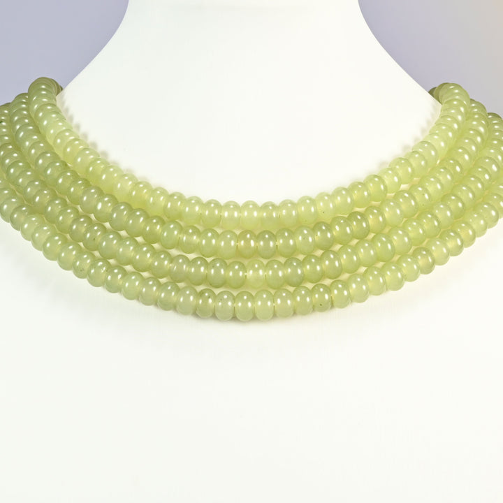 Green Grape dyed jade gemstone rondelle beads shown on a display bust as a layered collar, several strands stepping down in a row