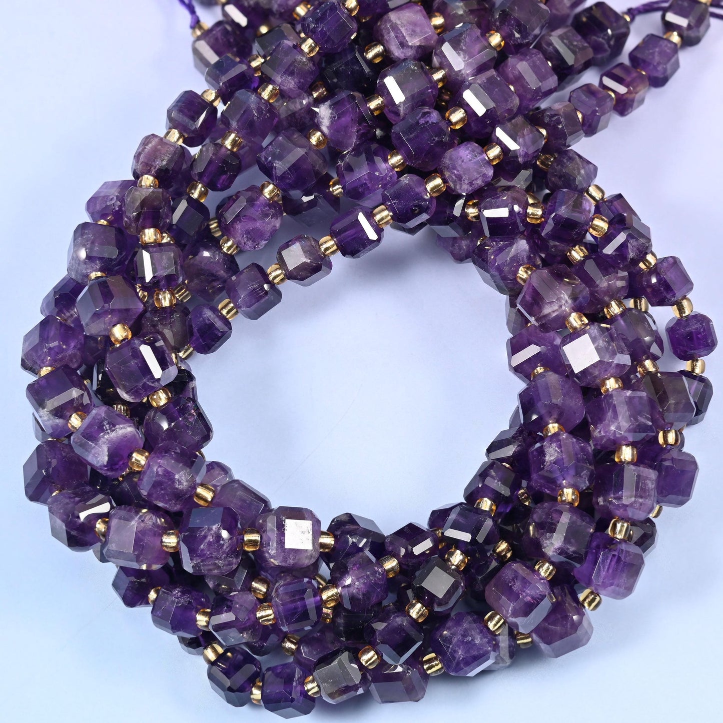 Deep grape purple cubes veined with paler lilac and milky white zoning, faceted at the corners so each flat face throws its own highlight.