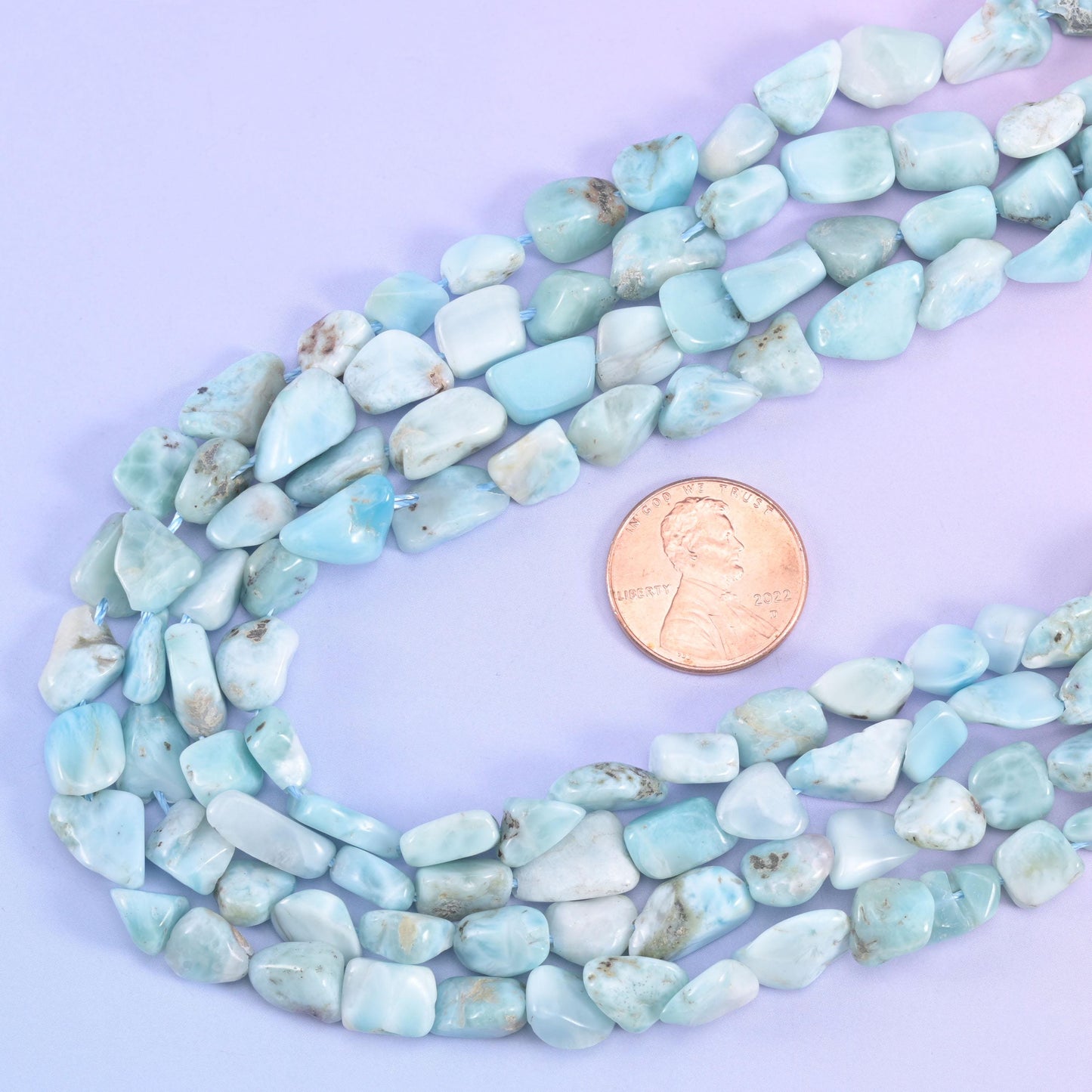 Nugget strands looped around a US penny, giving scale for the 6-8mm irregular beads