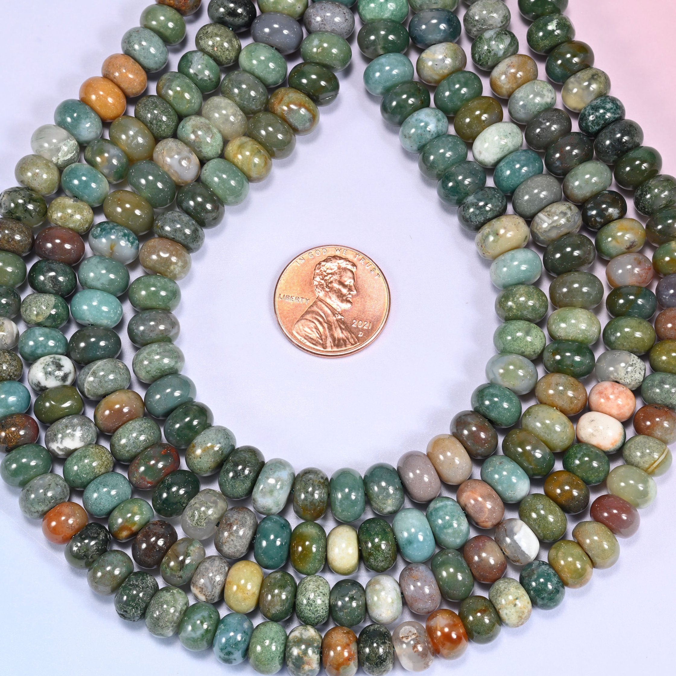 Close-up of coiled Indian Agate beads showing the natural texture and mineral inclusions.
