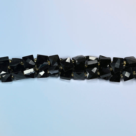 Strands of natural black onyx faceted flat square beads twisted together in a horizontal row