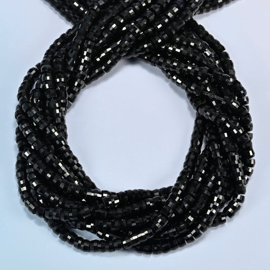 Black onyx faceted heishi disc beads coiled into overlapping loops, whole strands of solid black stone