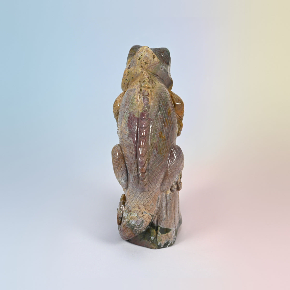 Back view of the ocean jasper chameleon carving showing the spine ridge and curled tail
