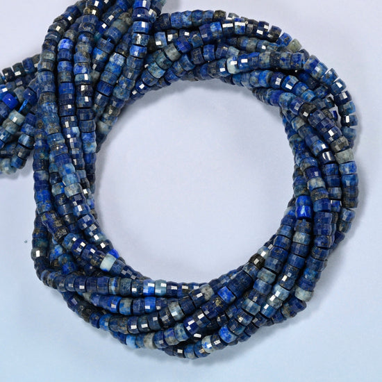 Dark blue lapis faceted heishi disc beads coiled into overlapping loops, whole strands of deep blue stone