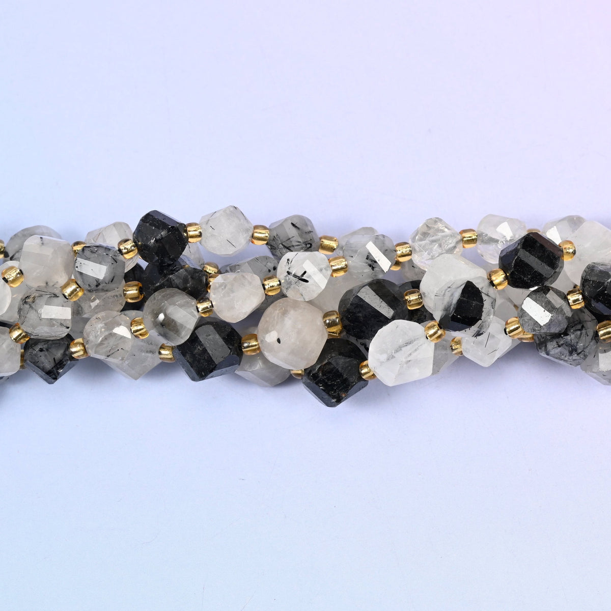 Clear to snowy white quartz shot through with jet-black tourmaline needles, running from beads with only a few fine dark threads to beads that are almost solid black