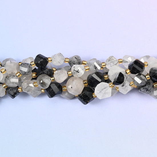Clear to snowy white quartz shot through with jet-black tourmaline needles, running from beads with only a few fine dark threads to beads that are almost solid black