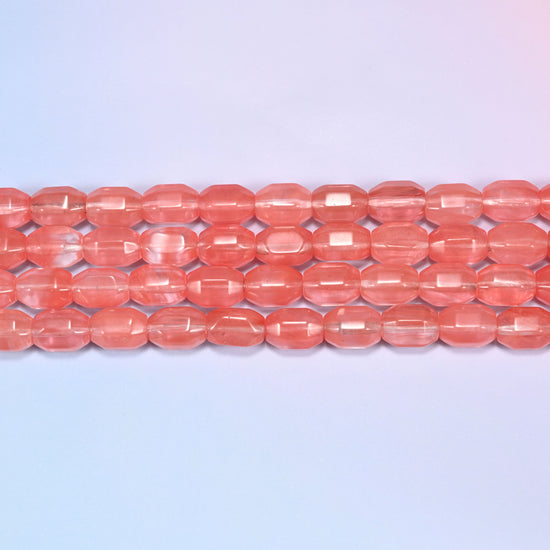 Close-up rows of coral pink faceted glass barrel beads laid flat, showing the translucent glassy finish.