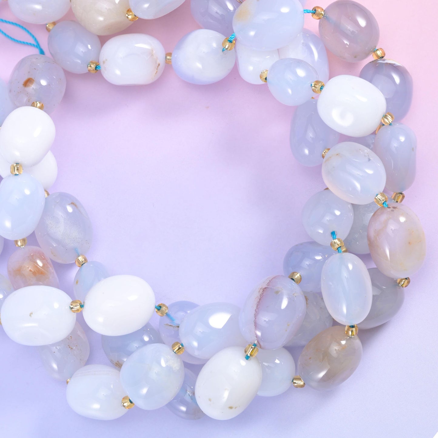 Coiled loops of blue white chalcedony strands with the blue stringing cord just visible