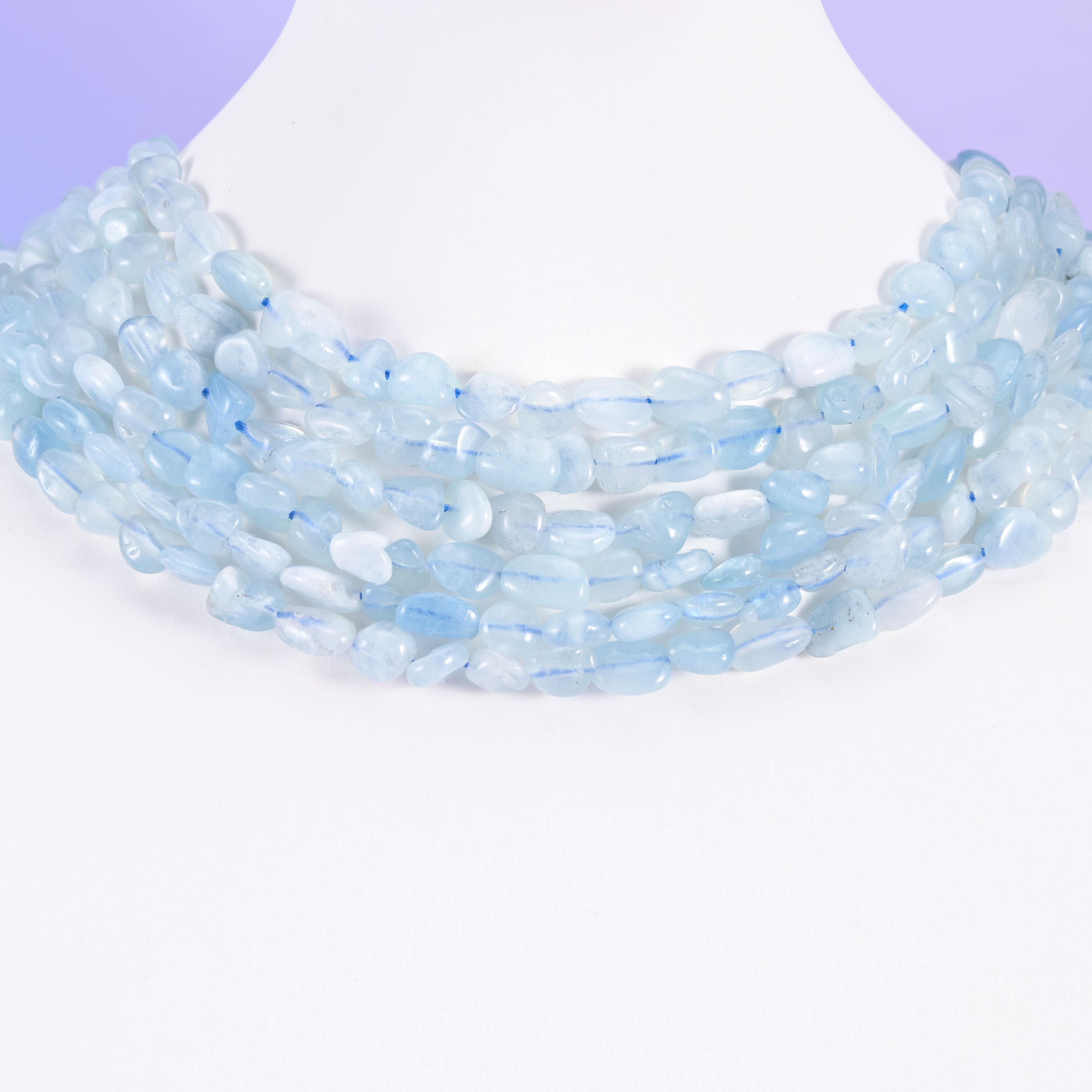 Aquamarine pebble nugget strands on a white display bust, worn as a layered collar