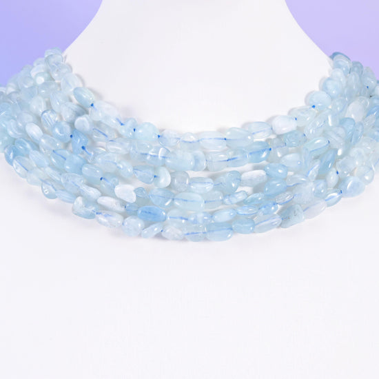 Aquamarine pebble nugget strands on a white display bust, worn as a layered collar