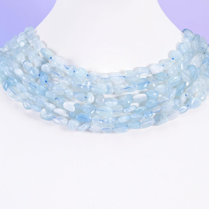 Aquamarine pebble nugget strands on a white display bust, worn as a layered collar