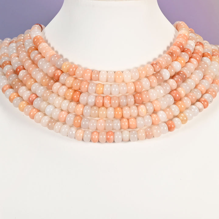Multi-strand Pink Aventurine necklace laid flat on a mannequin neck form against a lavender background.